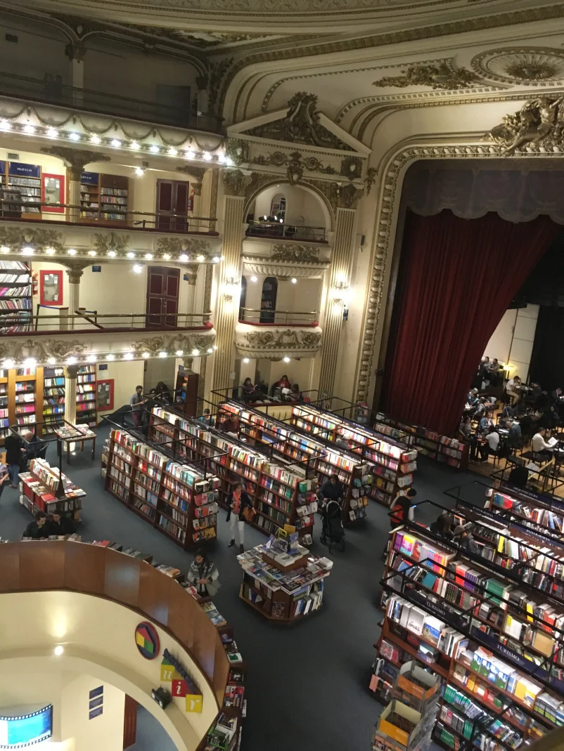A top view of several bookshelves approaching a stage.