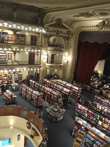 A birdseye view of a theatre stage. with three tiers of balconies. Instead of rows, there are bookshelves.
