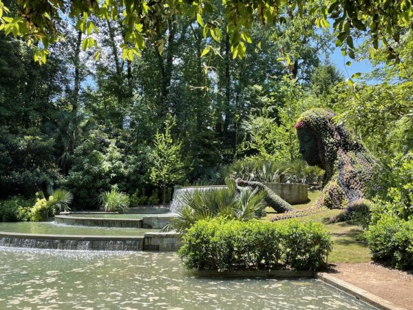 A garden sculpture of a women leaning over manmade waterfalls