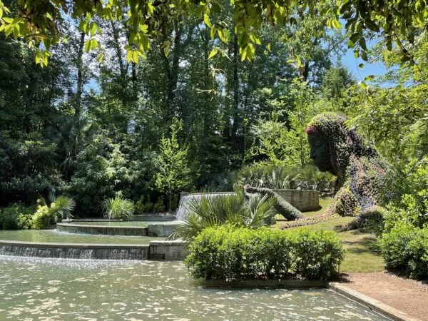 A garden sculpture of a women leaning over manmade waterfalls