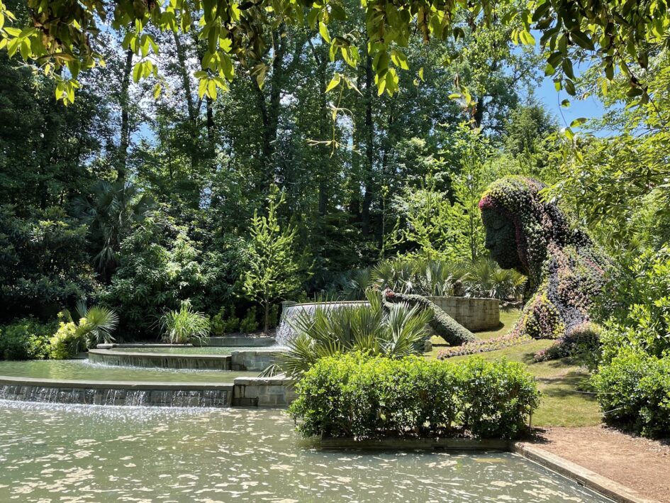 A garden sculpture of a women leaning over manmade waterfalls